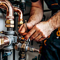 © KimSunHo | freepik.com | Klempner, der mit Kupferrohren und Fittings arbeitet
